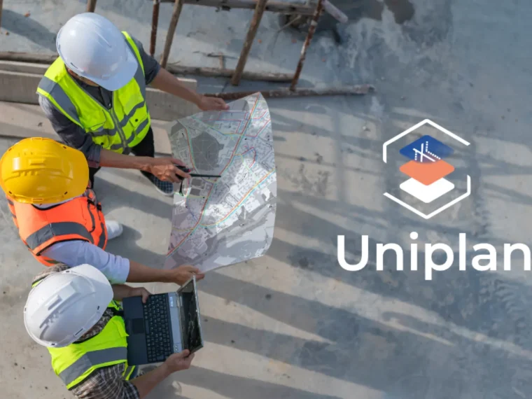 3 personnes dans un chantier consultent un plan dans les mains et 1 ordinateur