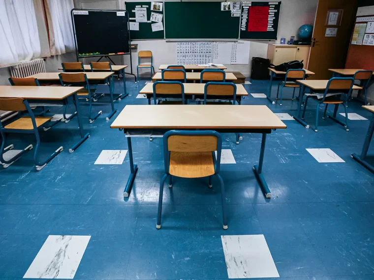 Une salle de classe vide avec des chaises et des bureaux