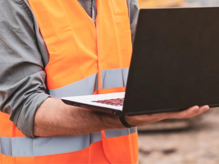 DICT, un homme en tenue de chantier avec son ordinateur