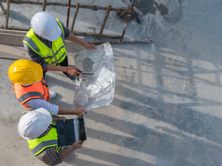 Uniplan, 3 hommes qui regardent un plan sur un chantier